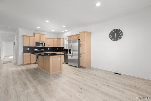 kitchen with light brown cabinets, stainless steel appliances, crown molding, and light hardwood / wood-style floors