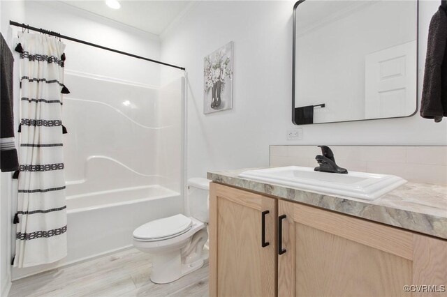 full bathroom featuring ornamental molding, vanity, wood-type flooring, shower / bathtub combination with curtain, and toilet