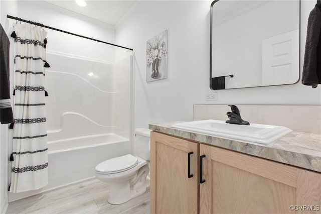 full bathroom with toilet, wood-type flooring, ornamental molding, vanity, and shower / bathtub combination with curtain