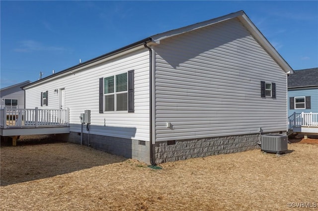 view of side of property featuring central air condition unit and a wooden deck