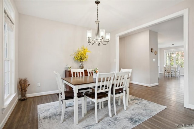 dining area featuring dark wood-type flooring and a chandelier