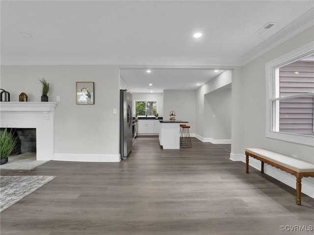 living room with ornamental molding, a fireplace, and dark wood-type flooring