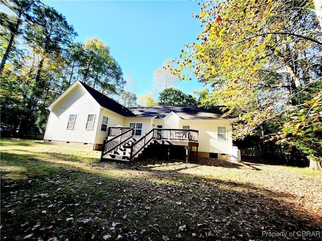 back of house with a lawn and a deck