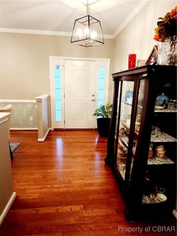 entrance foyer featuring a chandelier, wood-type flooring, and ornamental molding