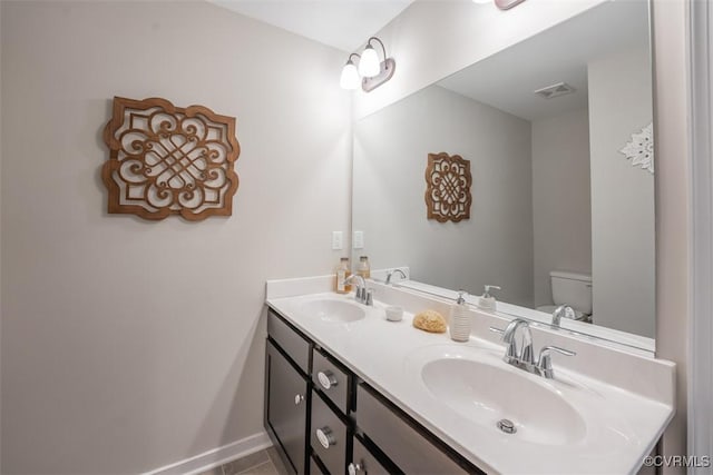 bathroom featuring tile patterned floors, vanity, and toilet