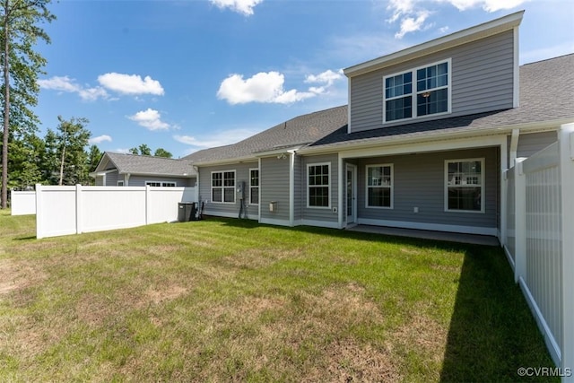 rear view of house with a lawn and central air condition unit