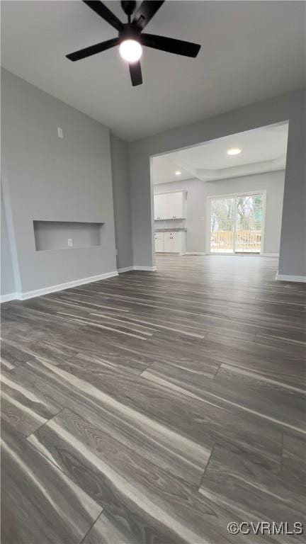 unfurnished living room with ceiling fan and dark hardwood / wood-style floors