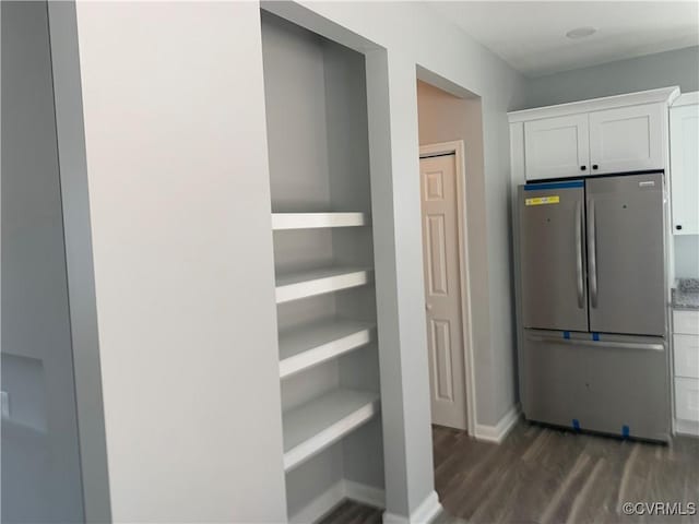 kitchen featuring white cabinets, stainless steel fridge, and dark hardwood / wood-style flooring