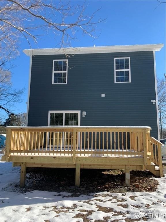 snow covered rear of property featuring a deck