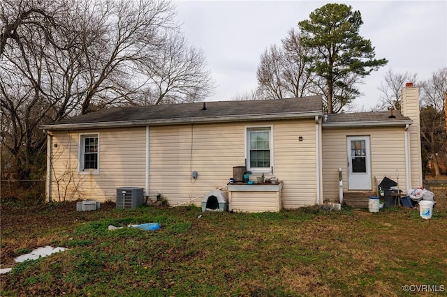 back of property with a lawn and cooling unit