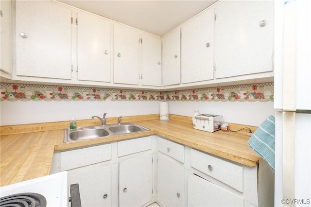 kitchen featuring white cabinetry and sink