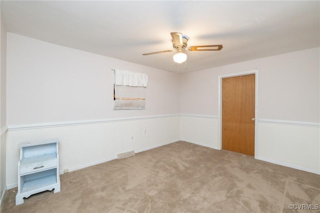 carpeted spare room with ceiling fan