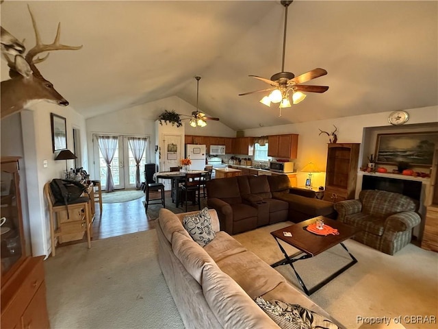 carpeted living room featuring french doors, vaulted ceiling, and ceiling fan