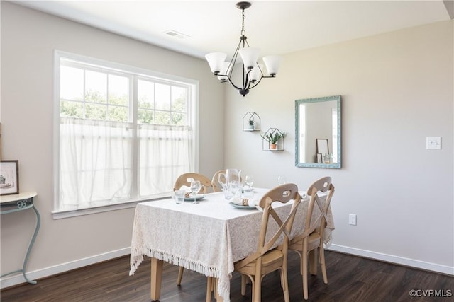 dining area featuring dark wood-type flooring, a wealth of natural light, and a chandelier