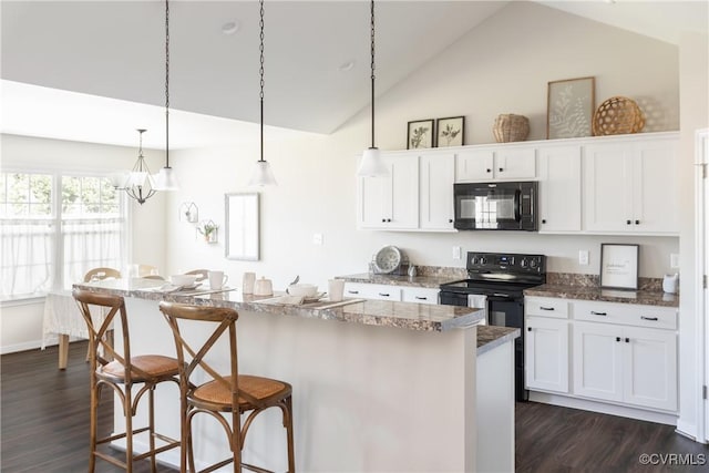 kitchen featuring black appliances, pendant lighting, a center island, white cabinetry, and a breakfast bar area