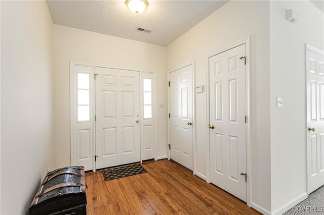 entryway featuring hardwood / wood-style floors and a textured ceiling