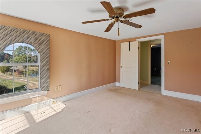 carpeted spare room with ceiling fan