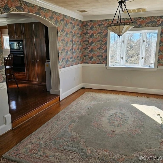 unfurnished dining area with wood-type flooring and crown molding