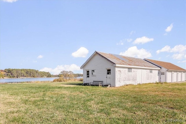 view of home's exterior with a yard and a water view