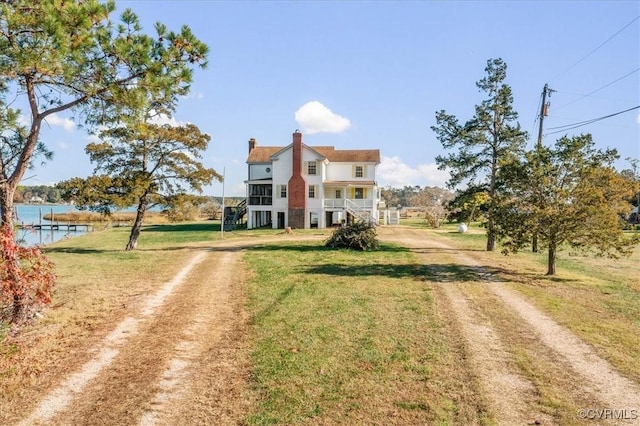 view of front facade featuring a water view and a front lawn