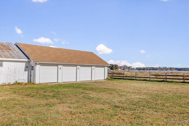 view of yard featuring a rural view, driveway, a garage, and fence