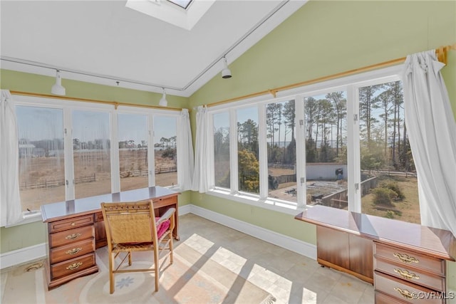 sunroom featuring lofted ceiling with skylight and track lighting