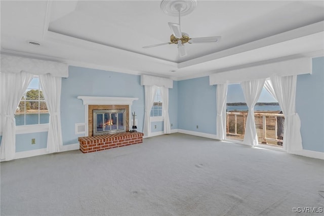 unfurnished living room featuring visible vents, a raised ceiling, carpet, a fireplace, and baseboards