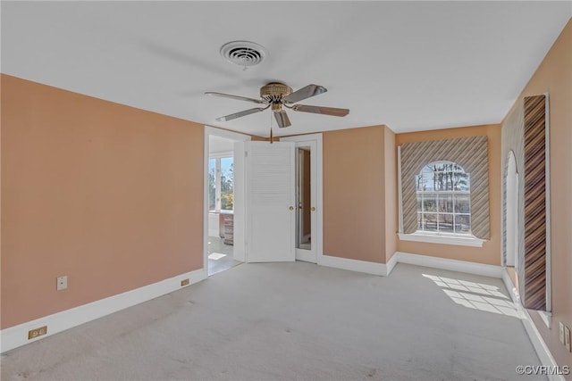 carpeted spare room with a wealth of natural light, visible vents, and baseboards