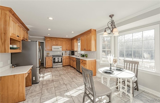 kitchen featuring appliances with stainless steel finishes, tasteful backsplash, a chandelier, sink, and decorative light fixtures