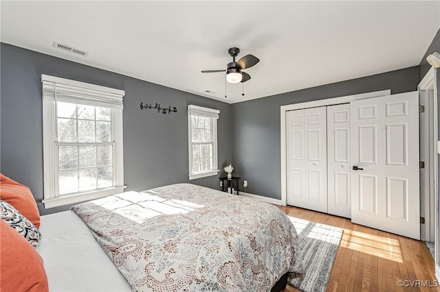 bedroom with light wood-type flooring, a closet, and ceiling fan