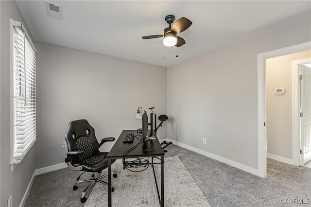 carpeted office space featuring ceiling fan