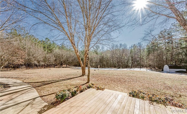 view of yard with a deck and a storage shed