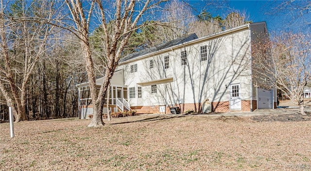 back of property featuring a garage and a sunroom