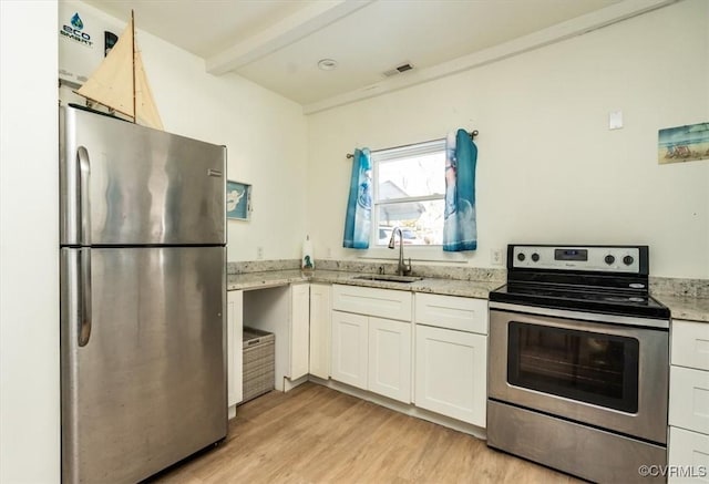 kitchen featuring appliances with stainless steel finishes, light hardwood / wood-style floors, beam ceiling, sink, and white cabinetry