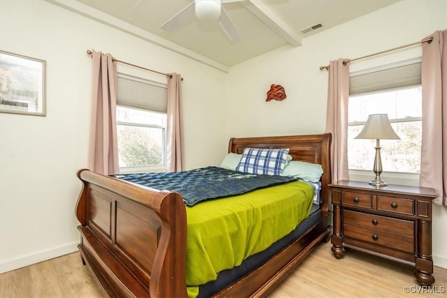 bedroom with ceiling fan, light hardwood / wood-style floors, and beam ceiling