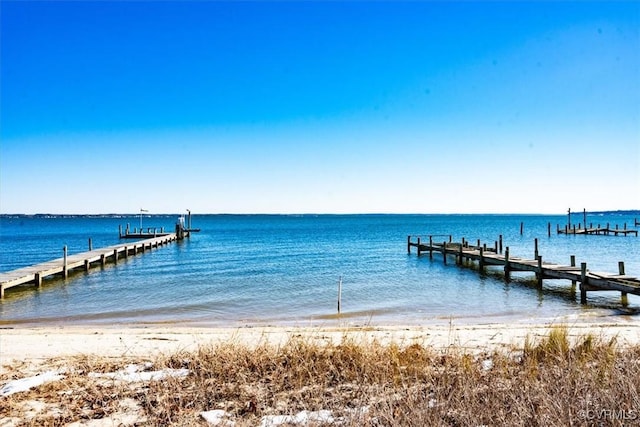 dock area featuring a beach view and a water view