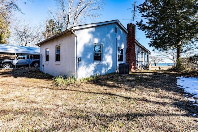 view of property exterior with a yard, cooling unit, and a carport