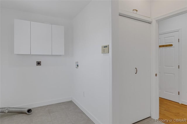 washroom with hookup for an electric dryer, hookup for a washing machine, and cabinets