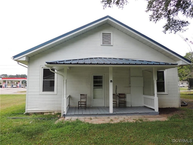 back of house featuring a yard and covered porch