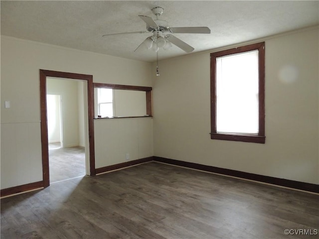 empty room with ceiling fan, crown molding, and dark hardwood / wood-style floors