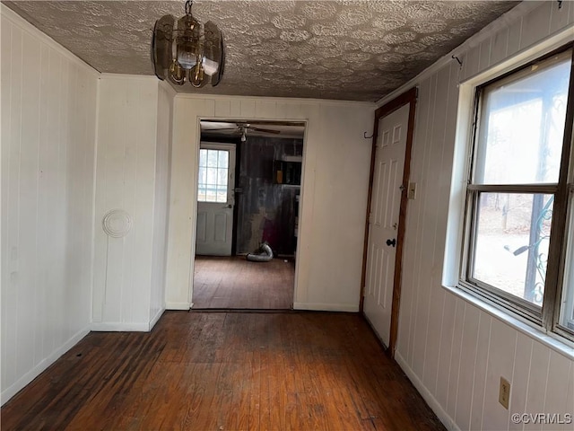 hall featuring dark hardwood / wood-style flooring, crown molding, and an inviting chandelier