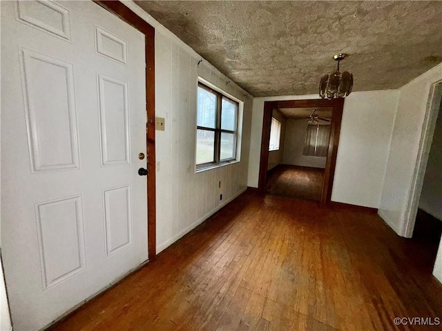 hall featuring a textured ceiling and dark wood-type flooring