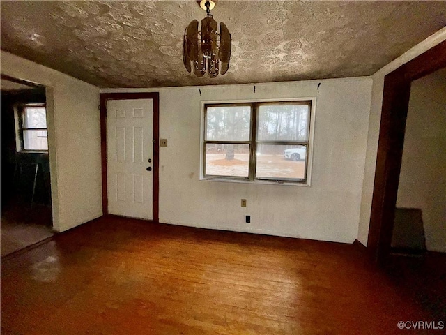 entrance foyer with hardwood / wood-style flooring and an inviting chandelier