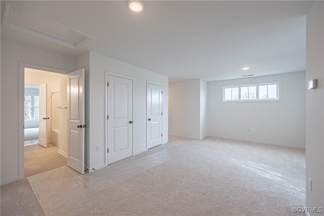 basement with a wealth of natural light and light carpet