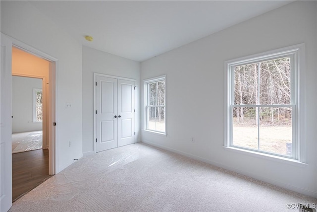 unfurnished bedroom featuring carpet and multiple windows