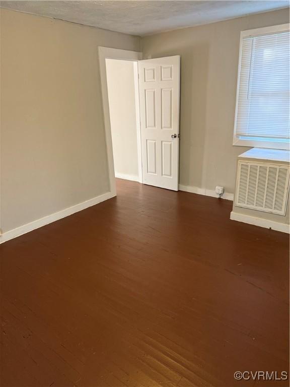 unfurnished room featuring dark wood-type flooring