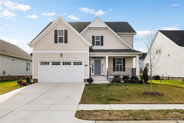 view of front of home with a front lawn, covered porch, and a garage