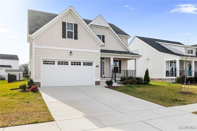 view of front of property featuring a front yard, a garage, and covered porch