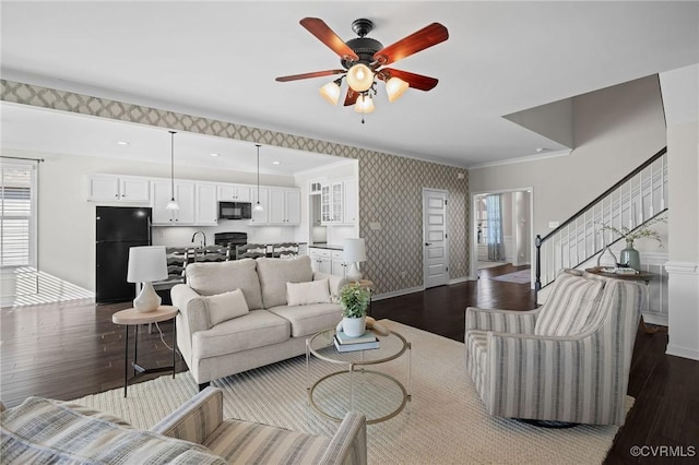 living room featuring dark hardwood / wood-style floors, ceiling fan, and crown molding