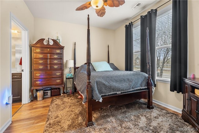 bedroom featuring light wood-type flooring, ceiling fan, and ensuite bathroom